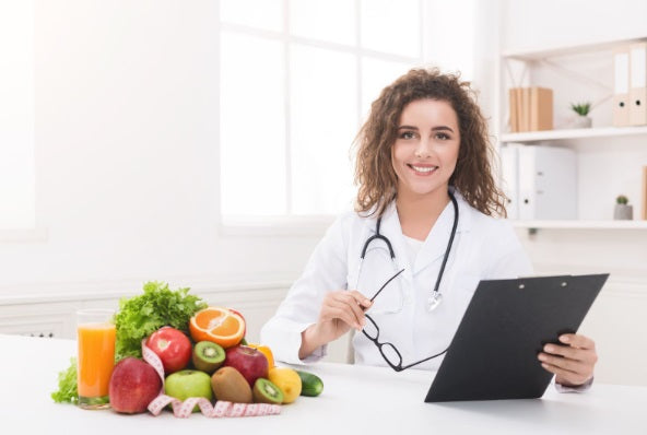 Mujer nutricionista mostrando portapapeles en blanco en la oficina